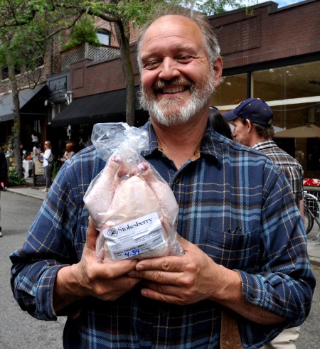 Jerry Stokesberry of Stokesberry Sustainable Farm holding one of his delicious chickens at Ballard Farmers Market. Copyright Zachary D. Lyons.